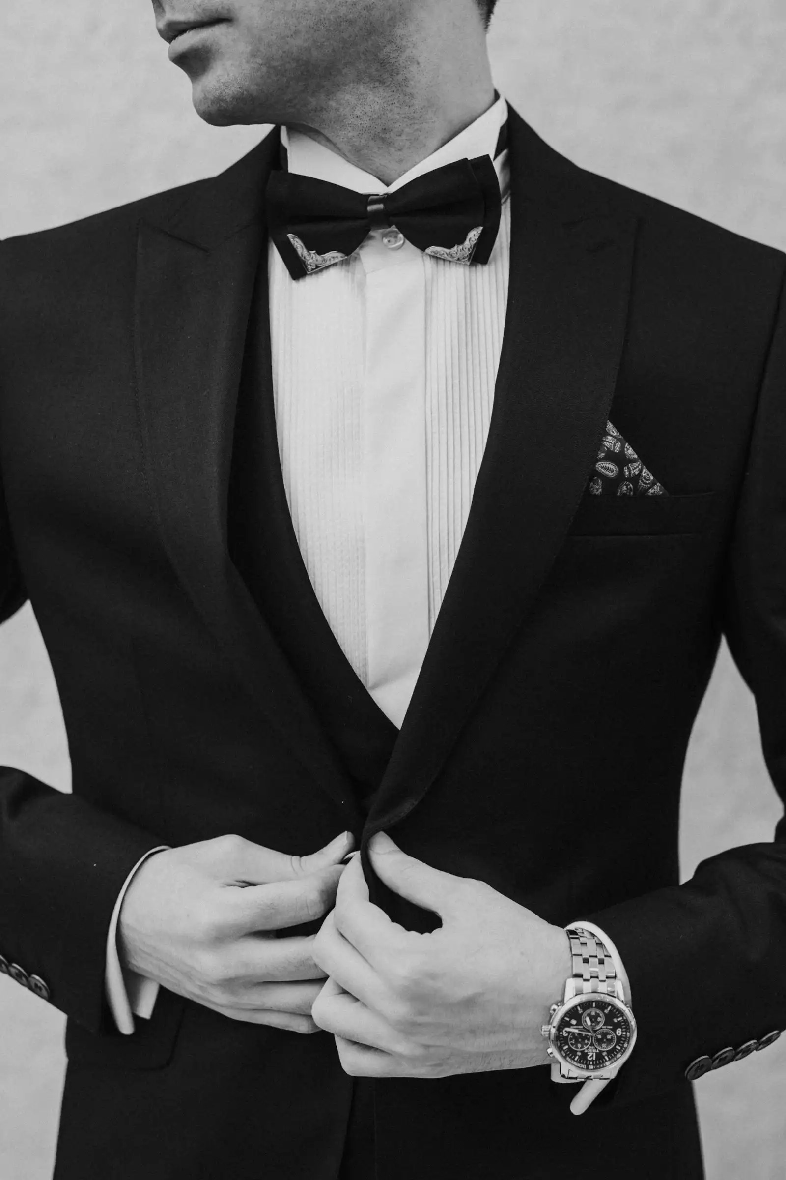 A man buttoning a tailored suit jacket