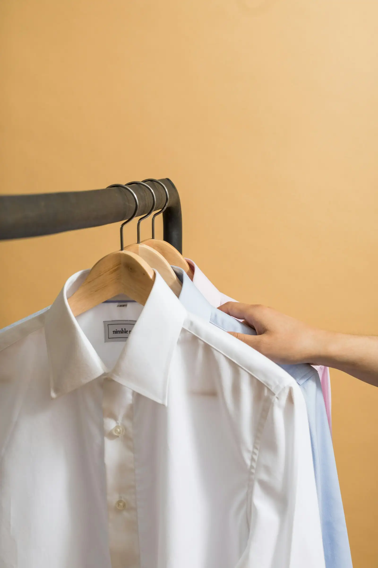 Dress shirts on hangers in a menswear shop
